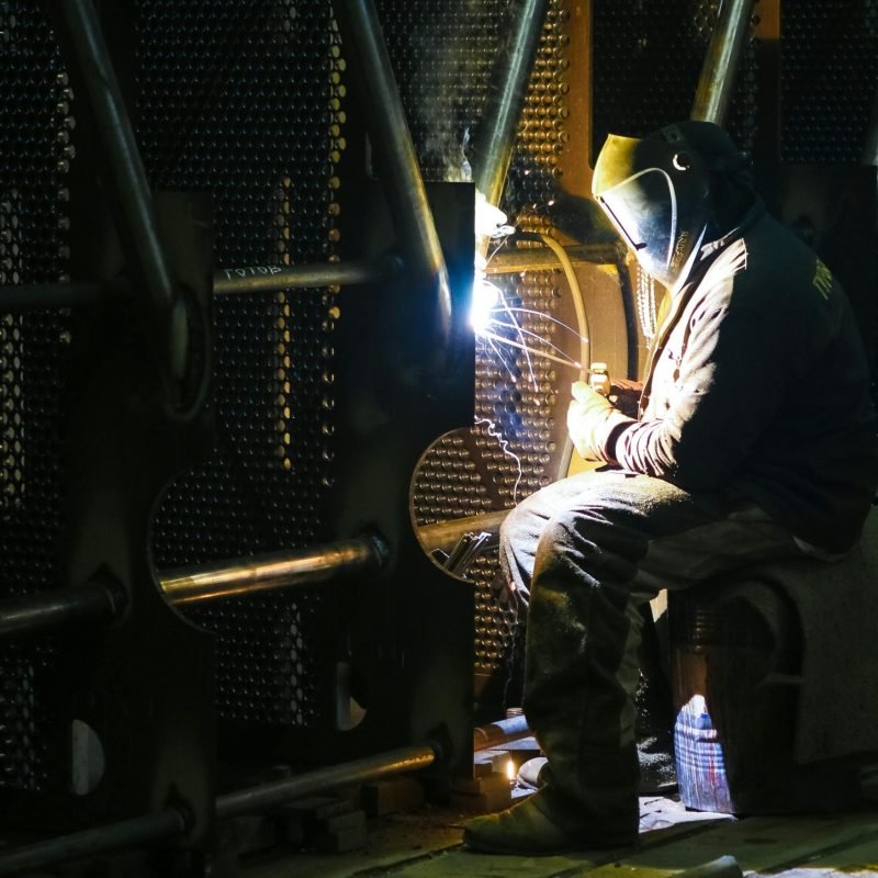 A professional welder working in an industrial factory setting, ensuring quality metalwork.
